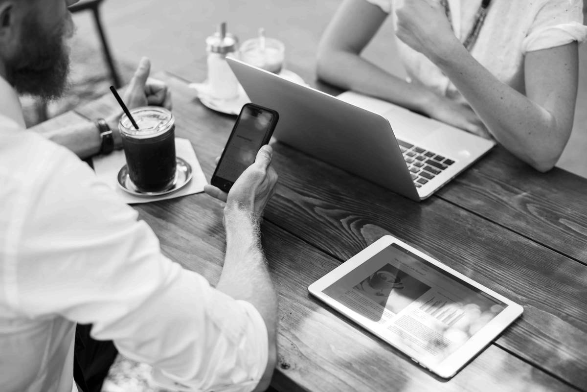 Colleagues meeting around a table with a laptop, phone and tablet